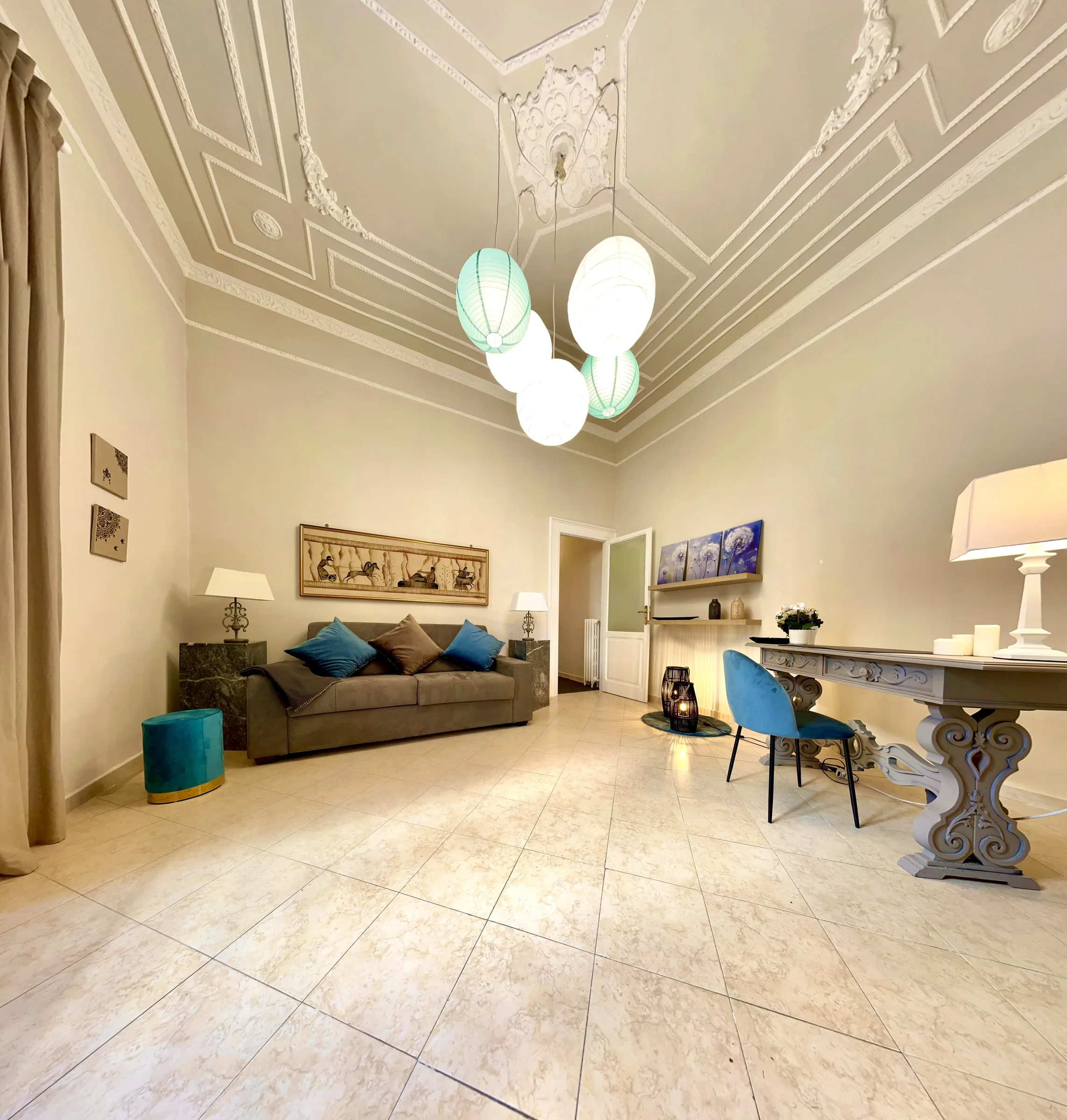 Soggiorno con soffitto decorato, divano e lampadari a sfera